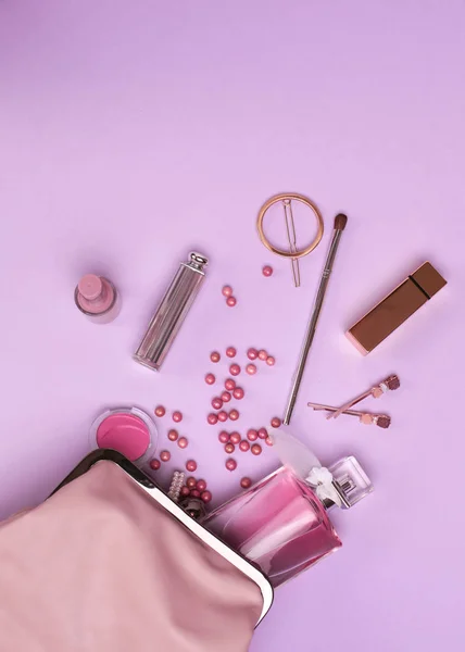 Produtos de maquiagem com saco cosmético e flores no fundo de cor — Fotografia de Stock