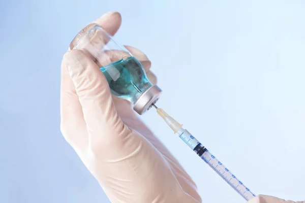 Руки с бутылкой вакцины — стоковое фото