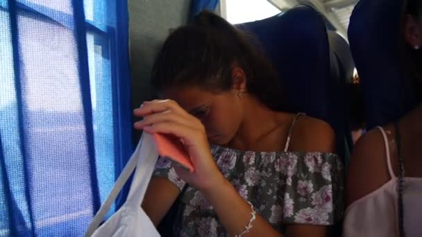 Girl looks for headphones in bag at closed curtain closeup — Stock Video