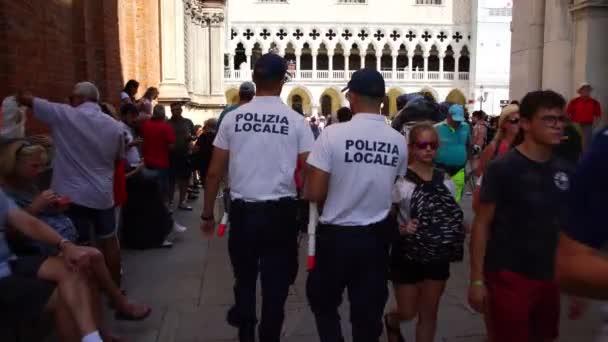 Agentes de policía caminar a través de turista multitud vista trasera — Vídeos de Stock