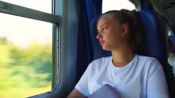 Girl teenager looks out train window falling asleep closeup — Stock Video