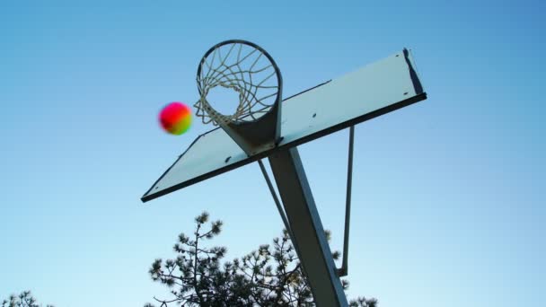 Bola de colores golpea y pierde cesta cerca de tiro de ángulo bajo — Vídeos de Stock