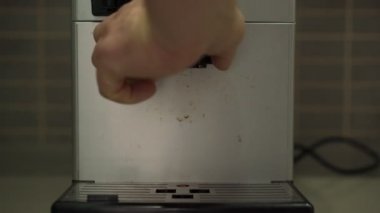 İnsanlar paslanmaz çelik parçaları kahve makinesinden çıkarıyorlar.