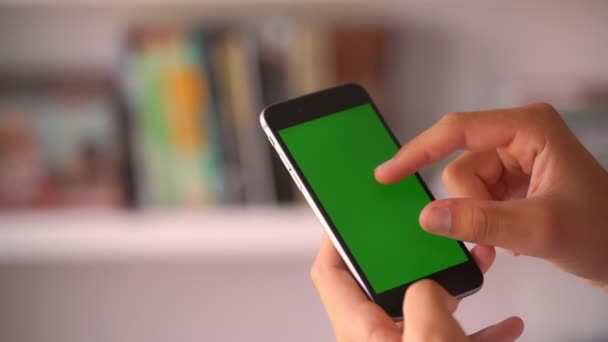 Meisje handen scroll groene chroma key afbeelding bij wazige boeken — Stockvideo