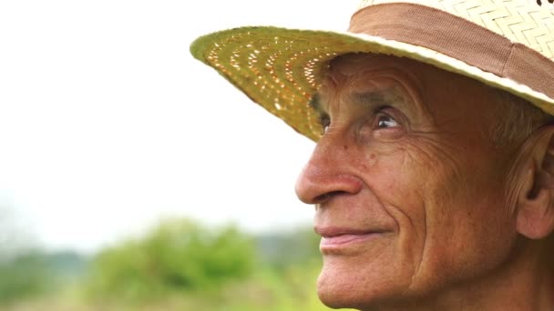 Das Gesicht eines alten Mannes blickt auf und lächelt in Zeitlupe — Stockvideo