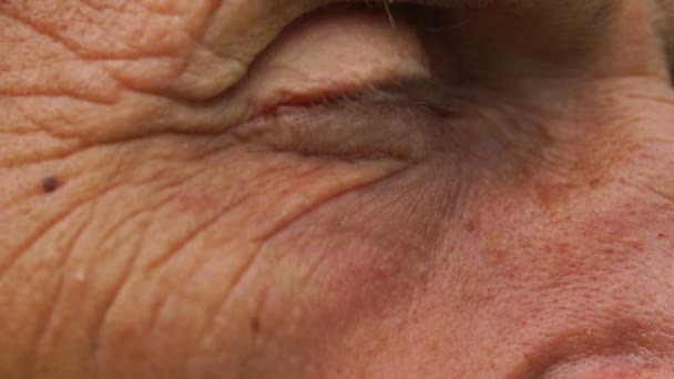 Old man brown eye looks at sky slow motion close side view — Stock Video