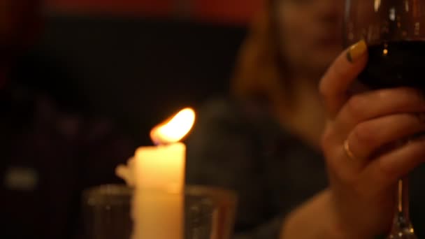 Wax candle flame against woman drinking red wine slow motion — Stock Video