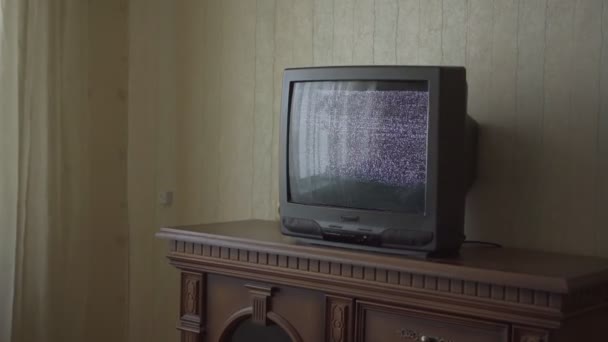 Schwarzes TV-Set mit blinkenden Wellen steht auf Schubladeneinheit — Stockvideo