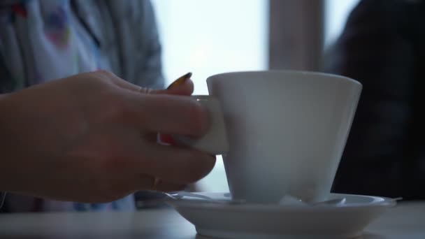 Žena sedí u bílého stolu v útulné restauraci detailní up — Stock video