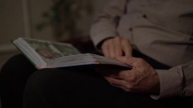 Son sınıf öğrencisi yavaş çekimde resimli kitabın sayfalarını çeviriyor.