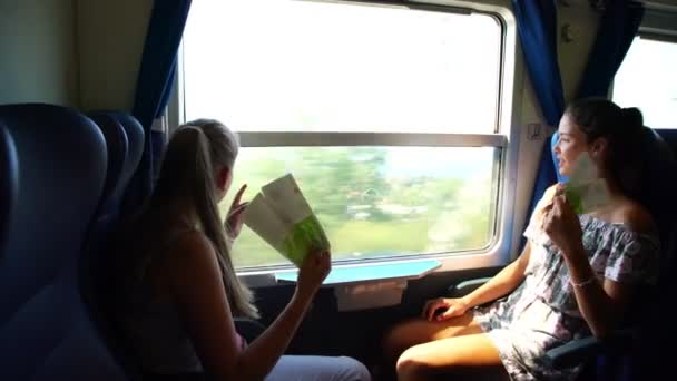 Leuke meisjes golf brochures en punt om te bekijken buiten trein — Stockvideo