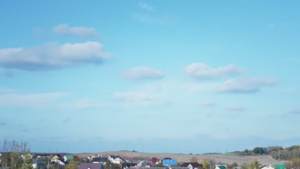Time lapse witte wolken zweven in blauwe lucht boven dorp — Stockvideo