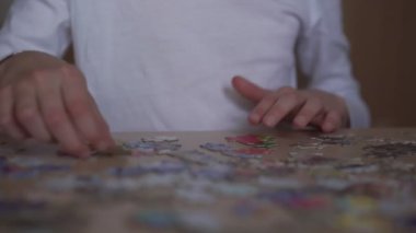 Beyaz tişört giyen okul kızı bulmaca parçalarını birbirine bağlıyor