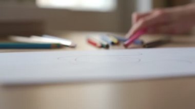 Beyaz tişört giyen liseli kız, kadın portresi çiziyor.