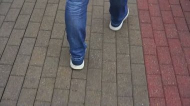 Kotlu, spor ayakkabılı, şemsiyeli bir adam.