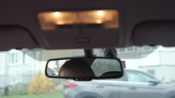 Achteruitkijkspiegel en mooie vrouw gezicht in auto cabine — Stockvideo