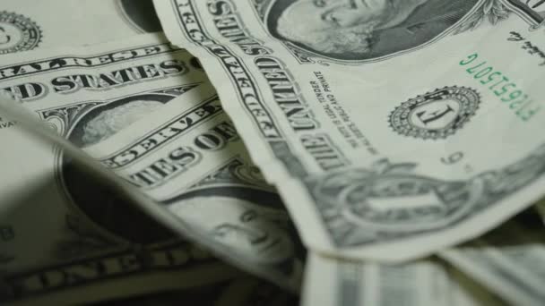 Promáčknuté dolarové bankovky leží na velké hromadě peněz blízko — Stock video