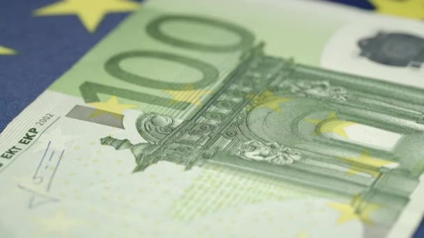 100 евро банкноты зеленого цвета лежат на голубом флаге — стоковое видео