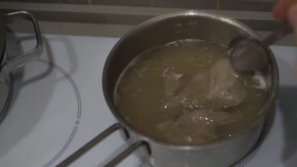 Woman stirs pork meat pieces with spoon preparing dish — Stock Video