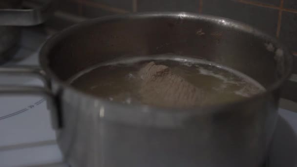 Pedaços de carne de porco ferver na panela de metal no fogão na cozinha — Vídeo de Stock