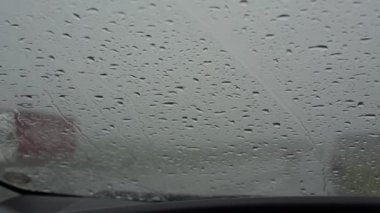 Bulanık tarlalar arasında ıslak yol boyunca çeşitli arabalar sürüyor.