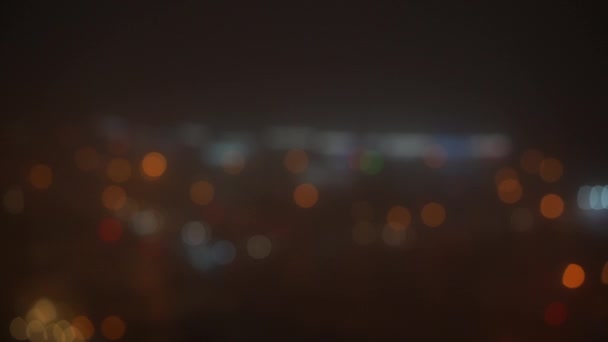Niewyraźny widok pojazdów kierujących się na nocne światła miejskie — Wideo stockowe