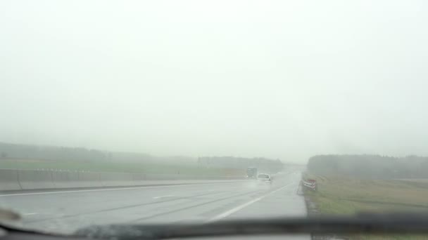 Různé automobily řídit podél šedé mokré silnice po dešti — Stock video