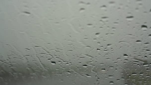 Большие капли дождя падают на автомобильное лобовое стекло против автомобилей — стоковое видео