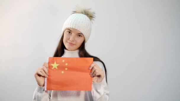 Chica feliz sostiene bandera nacional de China contra la pared blanca — Vídeo de stock