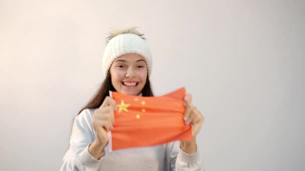 Mädchen schüttelt chinesische Nationalflagge auf hellem Hintergrund — Stockvideo