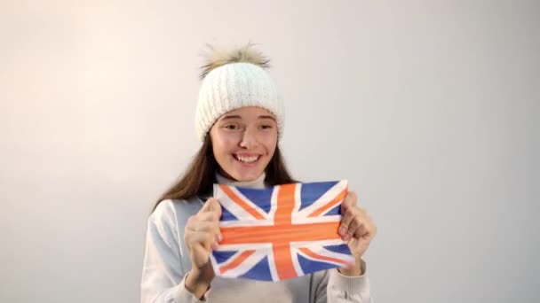 Chica emocional sacude bandera nacional del Reino Unido en el estudio — Vídeos de Stock