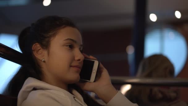 Teenager sits at ferry cafe and talks with friend on gadget — Stock Video