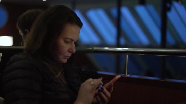 Femme se trouve dans l'espace public ferry et surfe sur les réseaux sociaux — Video