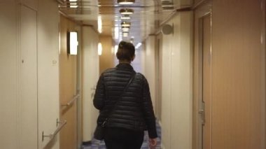 Genç kadın Helsinki Tallinn feribot koridorunda yürüyor.