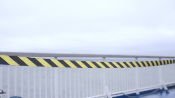 Olas de viento franja amarilla y negra por pasamanos de metal ferry — Vídeo de stock