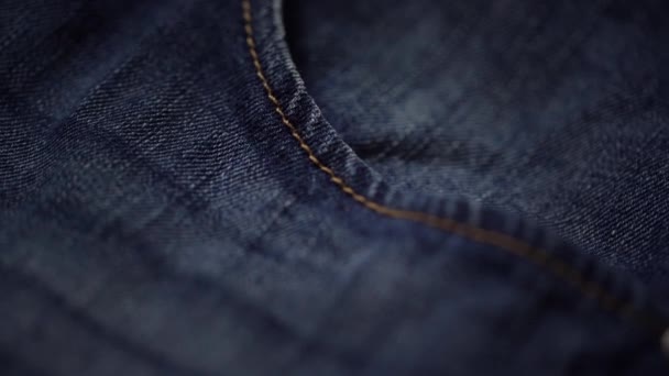Blauwe jeans zak met gele draad steken roteert — Stockvideo