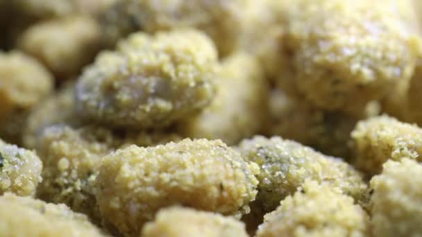 Nuggets de pollo empanados crudos con especias se encuentran en primer plano plato — Vídeo de stock