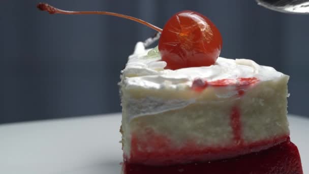 Person takes white cream from cherry cake piece close view — Stock Video