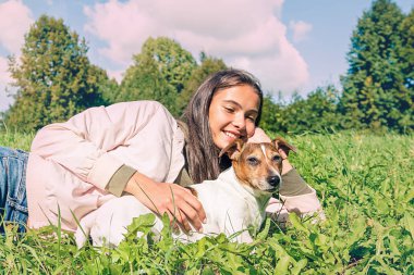 Köpek Jack Russell Terrier ve genç bir kız yerde yatıyor. 