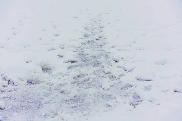 Traces de chaussures dans la neige sur le chemin à travers la rivière gelée — Photo
