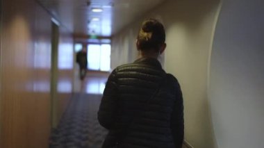 Ceketli esmer Helsinki Tallinn feribot salonu boyunca yürüyor.
