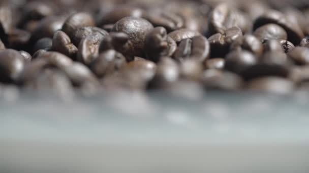 Brown coffee beans pile rotates and becomes blurred closeup — Stockvideo