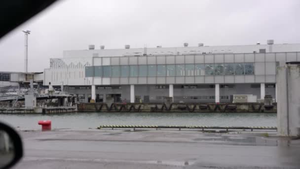 Voitures roulent le long de la route contre le bâtiment portuaire de Tallinn — Video