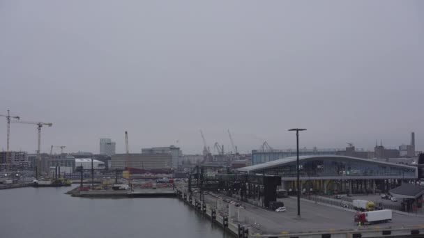 Порт Хельсинки с грузовиками против строительных кранов — стоковое видео