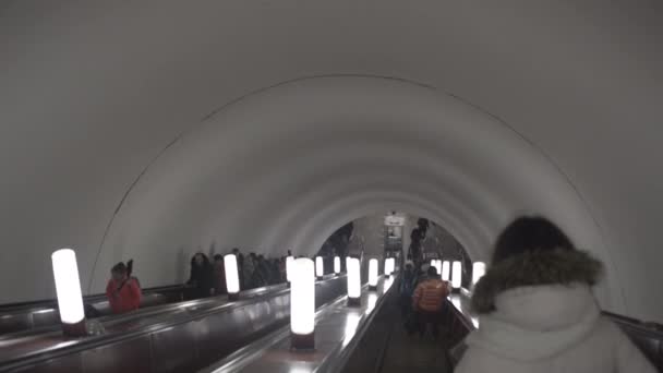 Mädchen fährt Rolltreppe in U-Bahn an Menschen vorbei — Stockvideo