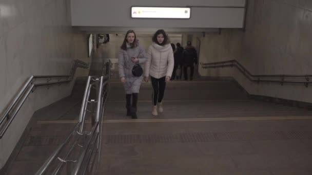 Filles montent les escaliers dans le métro urbain et regarde smartphone — Video