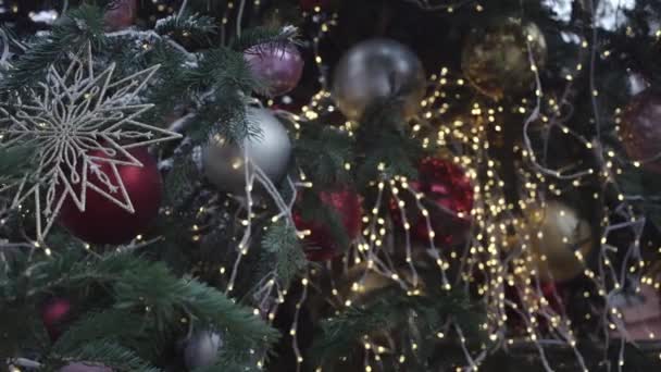 Buntes Spielzeug hängt auf Kirmes am Weihnachtsbaum mit Girlanden — Stockvideo