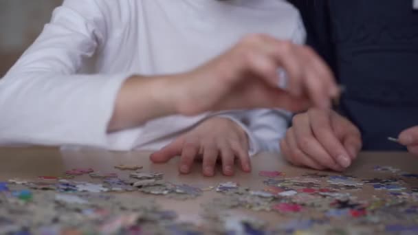 Бабушка и внучка сидят и собирают головоломки — стоковое видео