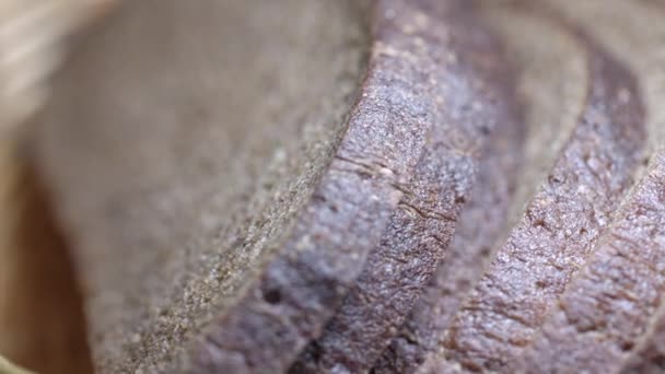 Pan de centeno en rodajas se encuentra en la cesta de mimbre de pie sobre la mesa — Vídeos de Stock