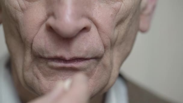 Homme âgé prend la pilule et boit de l'eau sur fond clair — Video